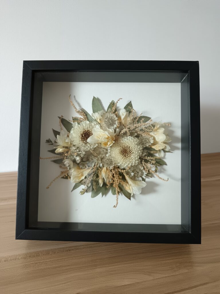 Cadre souvenir en fleurs séchées naturelles, tons crème et dorés. Création florale artisanale signée Invitation Florale, réalisée en Normandie près de Caen.